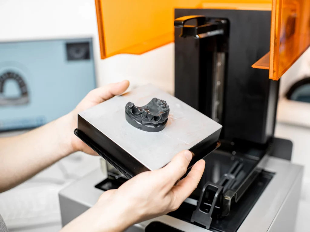 dental technician removing jaw model from a 3D printer